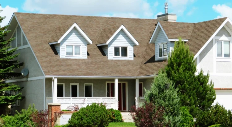 A two-story suburban house with dormer windows and a landscaped front yard